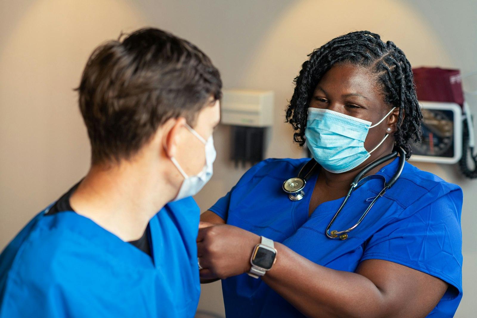 Two colleagues in scrubs supporting each other before their shift