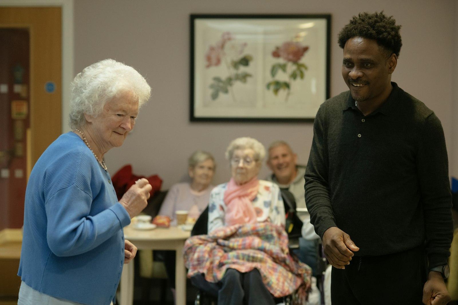 A support worker accompanies residents in a common lounge